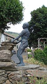 statue d'un homme soulevant une dalle de schiste