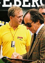 Phil Hill (polo jaune) avec Jackie Stewart lors du Grand Prix des États-Unis 1991