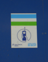 Photo : logo Bi-Bop bleu blanc vert au-dessus d'un symbole de téléphone tenu en main