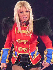 A woman with blond hair, wearing a blue, red, and black outfit.
