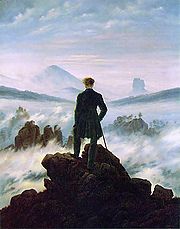  Tableau d'un homme debout tournant le dos au spectateur. Il est en haut d'une montagne, entouré de nugages et de brouillard. Il est vpetu de noir et contraste vivement avec les blancs, les roses et les bleus de l'atmosphère. Au lointain, on peut distinguer des affleurements de rochers.