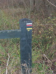 signalétique rouge et blanche du GR et jaune du PR sur un poteau de barrière