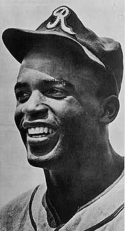 Photographie noir et blanc en gros plan du visage souriant de Jackie Robinson sous les couleurs des Royaux