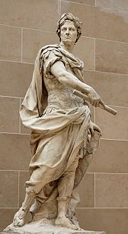 Statue en pied, le regard sévère, César porte la tunique militaire et une toge, ainsi que les lauriers.