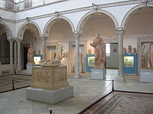 Vue de la salle de Carthage avec l’autel de la gens augusta au premier plan et la statue d’impératrice à l’arrière-plan.