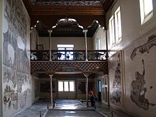 Salle d’Althiburos, ancienne salle de musique du palais avec une tribune et des mosaïques sur les murs et le sol.