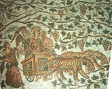 Mosaïque représentant le dieu de la vigne Bacchus sur un char tiré par des tigres et couronné par des personnages de son cortège, sur fond de vignes chatoyantes.
