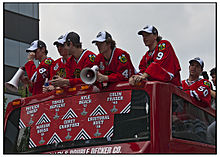 Photo de 6 joueurs des Blackhawks, dont deux tiennent un mégaphone.
