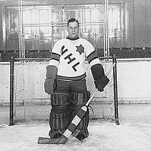 Charlie Gardiner dans un maillot portant l'inscription NHL devant un but de hockey