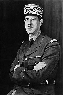 Photographie en noir et blanc de Charles de Gaulle, en uniforme de général de brigade. Son buste est tourné vers la gauche, et il a les bras croisés. Le cadrage masque ses jambes.