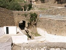 Vue sur une ruelle descendante bordée par des murets en pierre