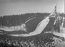 Une vue d'un tremplin de saut à ski avec la foule autour de la zone d'atterrissage