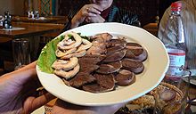 Assiette contenant différents morceaux de viande cuite, de couleur marron.