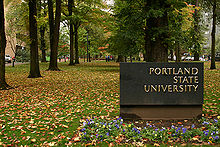 Vue du panneau de bienvenue à l'université devant plusieurs arbres.