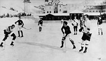 Photo noir et blanc d'un match de hockey en extérieur.