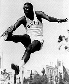 Photographie noir et blanc de Jackie Robinson lors d'un saut en longueur sous le maillot de l'UCLA