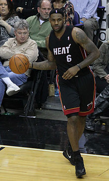 LeBron James sous le maillot noir du Heat, avec le ballon à la main.