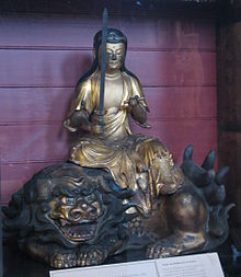 photo d'une statue japonaise en bronze du boddhisattva de Manjusri, portant une épée et assis sur un lion menaçant