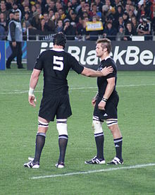 McCaw en 2011 pendant le match d'ouverture de la Coupe du monde de rugby à XV 2011. Il se tient à côté d'un coéquipier vêtu de noir pendant un arrêt de jeu.