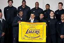 Les Lakers posent avec le président Obama. Un drapeau, tenu par les joueurs, indiquent les deux titres successifs.