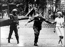 Pat Nixon sortant d'un hélicoptère, suivie par un soldat en uniforme et le pilote.