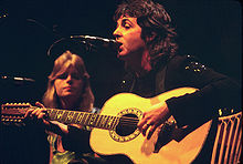 Paul McCartney jouant de la guitare acoustique en 1976