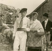 Pierre Desproges, jeune homme, en spectateur moqueur lors d'un défilé costumé organisé à l'occasion de la kermesse de l'école du château de Châlus-Chabrol, le 26 septembre 1958