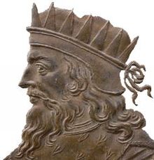 La médaille montre un homme barbu aux cheveux longs, portant une couronne sur la tête.