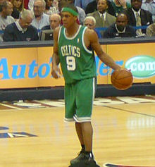 Le meneur de jeu Rajon Rondo dribblant avec la balle de basket-ball avec sa main gauche.