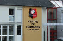 Photographie du logo du Stade rennais et de l'inscription « Centre de formation E.T.P. Odorico ».