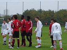 Photographie présentant un groupe de joueurs de 14 ans disputant un match de football.