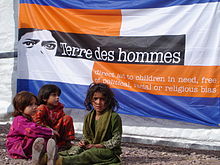 Photographie de 3 fillettes pakistanaises devant une banderole de Terre des hommes