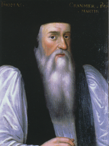 Portrait de l'archevêque Cranmer âgé. Il a un visage long avec une longue barbe blanche, un grand nez, des yeux noirs et des joues roses. Il porte des habits cléricaux sous un manteau noir avec des manches blanches et un chapeau sur la tête