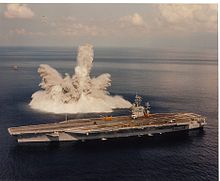 Photographie des gerbes d'eau projetées en l'air par l'explosion d'une bombe sous-marine, à proximité du navire.