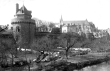 Photographie en noir et blanc de la tour du Connétable dans son environnement, le verger des douves, les remparts vers le nord, la cathédrale en arrière plan. Photo prise vers 1900