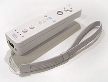 Une Wiimote, contrôleur de jeu de forme allongée semblable à une télécommande, posée sur une surface plane.