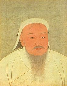 Portrait d'un homme grisonnant. Il porte une longue barbe et des anneaux à ses oreilles. Il est vêtu d'un chapeau et de vêtements blancs.