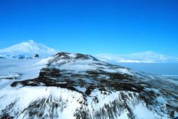 Vue de l'île de Ross depuis la péninsule de Hut Point avec de gauche à droite au dernier plan le mont Erebus, le mont Terra Nova et le mont Terror.