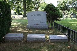 Photographie en couleurs de la pierre tombale de Jackie Robinson dans une partie ombragée du cimetière de Cypress Hills