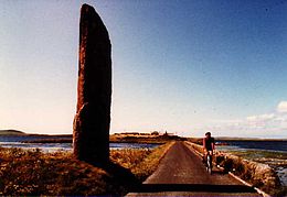 La Stenness Watch Stone se tient en dehors du cercle, à côté du pont moderne conduisant au cercle de Brodgar, qui divise le lac