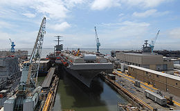 Vue du port de l'USS Carl Vinson, sur lequel on a installé des hangars en tôle démontables et du matériel de construction.