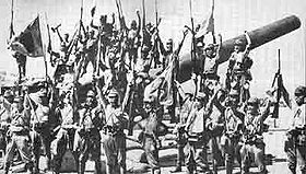 Soldats japonais victorieux, sur un canon de batterie américain.