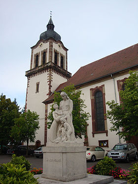 Église simultanée et monument aux morts au centre du village.