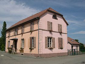 Photo de la mairie d'Eguenigue de couleur rose avec un toit en tuile rouge