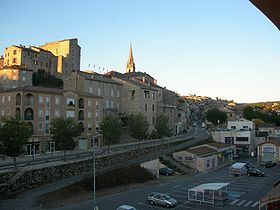 Au premier plan, la place de la Gare. Au second plan, la route départementale D104 reliant Aubenas à Alès. À l'arrière plan, le château et l'église.