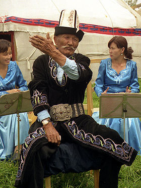 Un manastchi, conteur traditionnel kirghize, récitant l'épopée de Manas dans un campement de yourtes à Karakol