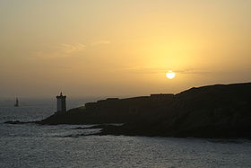 Silhouette de la presqu'île et du phare de Kermorvan lors d'un coucher de soleil.