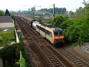 Image classique de la Grande Ceinture : au passage de Sucy-en-Brie, un train s'engage sur la « Complémentaire » en direction de Noisy-le-Sec. Noter à l'arrière plan, la gare de Sucy - Bonneuil sur le RER A