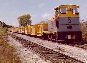 Le train composé d'une locomotive diesel et de wagonssur la voie ferrée en 1975.