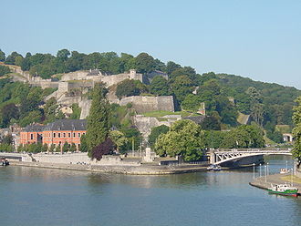 Le Parlement wallon à Namur (en rose), avec, en face la Meuse, derrière la Citadelle et, à sa gauche le confluent de la Sambre et de la Meuse, l'axe des deux rivières symbolisant la partie la plus peuplée de la Wallonie